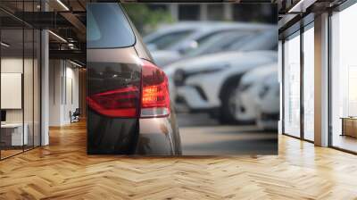 red tail light of brown car in large asphalt parking lot, transportation industry Wall mural