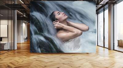 Beautiful woman model posing under waterfall wearing white swimwear Wall mural