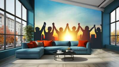 Silhouette of group business team making high hands over head in sunset sky in city for business success and teamwork Wall mural