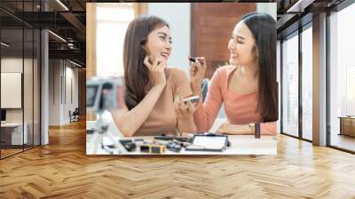 Two young beautiful asian woman professional beauty vlogger or blogger recording make up tutorial to share on social media
 Wall mural