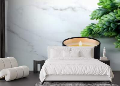 aroma scented candle in black tin cup lighting on the white marble table with plants for relax ambient in bedroom for celebration on valentine day of couple of lovers Wall mural