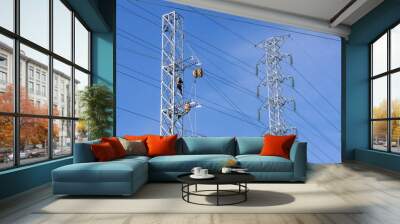 electricity transmission pylon with electricity engineer worker and blue sky background. Wall mural