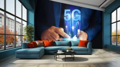 Business man using mobile smartphone with 5G icons flow on virtual screen concept. 5G High speed internet network. Wall mural