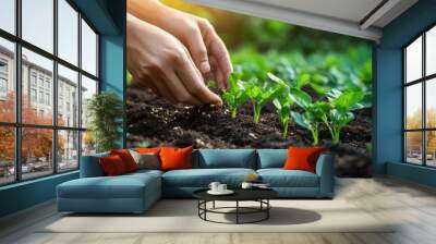 A close-up of hands planting seeds in rich soil, showcasing the beginning of a new crop season and sustainable farming practices. Wall mural