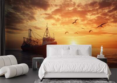 A fishing boat returning to harbor with nets full of fish, the sun setting over the horizon. Wall mural