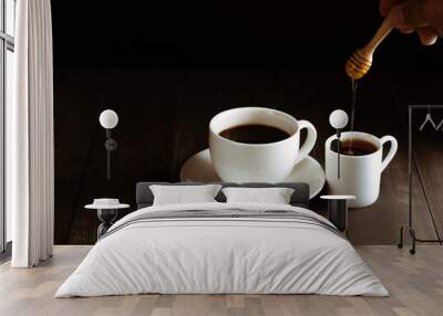 Coffee cup and sweet honey on black wooden background. Wall mural