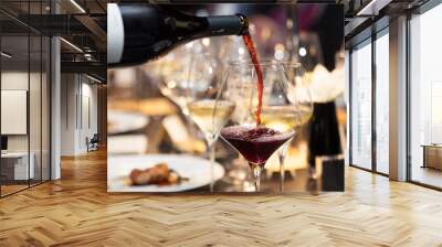 waitress pour red wine in the glass on the table in restaurant Wall mural