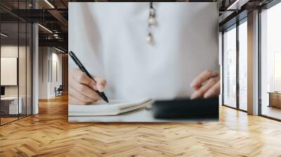 Hand of businesswoman writing on paper in office Wall mural