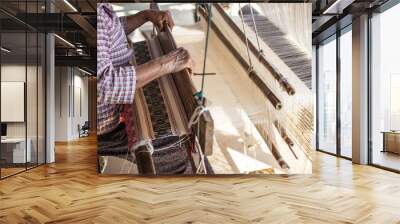 Woman weaving silk in traditional way at manual loom. Thailand Wall mural