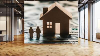 Two symbolic plastic figures stand in front of a conventional house, representing the dream of homeownership amidst a backdrop of numerous 100 USD bills, symbolizing wealth and prosperity Wall mural