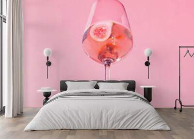 Minimal concept with wine glass on sunny day. Creative party idea, drink in the air. Fig cocktail on purple background. Wall mural