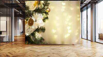 Christmas background. Christmas tree beautifully decorated with balls, bow, lights and dry oranges. Blur background with hearts. Wall mural