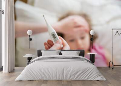 close-up thermometer. mother measuring temperature of her ill kid. sick child with high fever laying Wall mural