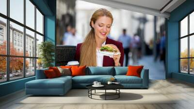 Young business woman talking on smartphone eating salad on lunch break in City Park living healthy lifestyle working on smart phone. Happy businesswoman Wall mural