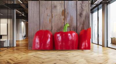 Three saturated Bulgarian peppers lie on the table Wall mural