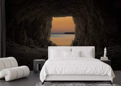 Exit from the cave overlooking the evening sea. Wall mural