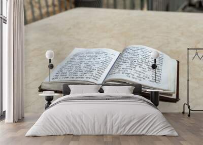 The open  holy book of Jews with the text of prayers in Hebrew - Tehelim, lies on a table near the Western Wall in the old city. of Jerusalem in Israel Wall mural