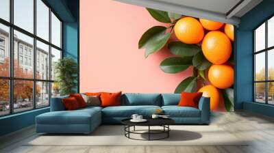 A cluster of ripe, juicy oranges with vibrant green leaves against a soft coral background, illustrating the richness and purity of fresh citrus fruits. Wall mural