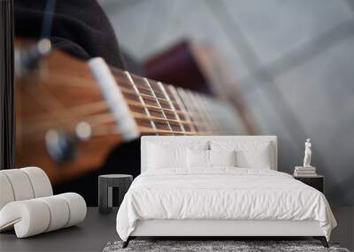 Hübsches Holz Gitarren Saiten Musikinstrument zum Rockmusik spielen in Oktav Resonanz vor unscharfem Hintergrund Wall mural