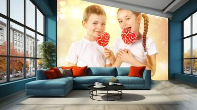 Little boy and girl with candy red lollipop in heart shape. Valentine's day art portrait. Wall mural