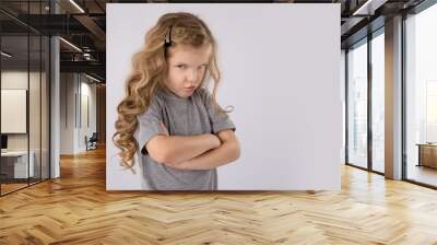 Portrait of angry and sad little girl isolated on white background Wall mural