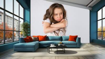 Portrait of angry and sad little girl isolated on white background Wall mural