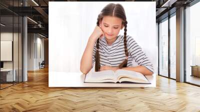 Education and school concept. Child is sitting at the desk and reading a book. Wall mural