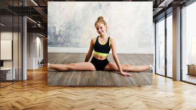 Flexible cute little girl child gymnast doing acrobatic exercise Wall mural