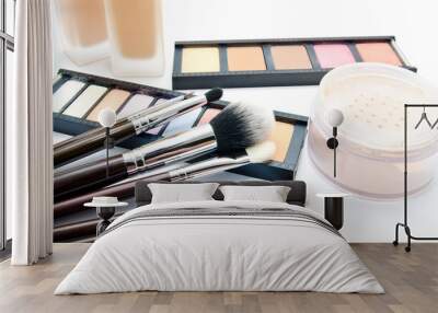 Various set of professional makeup brushes and cosmetics and palette of colourful eye shadows isolated Wall mural