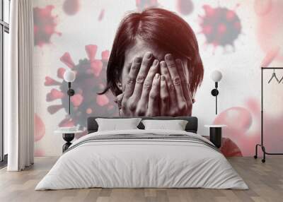 Concept of fear of coronavirus. Woman covers her face her hands on background with coronavirus. Wall mural