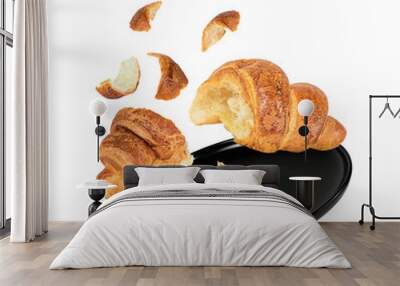 Fresh croissant divided in two and a black plate. Wall mural