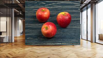 Three red apples on a dark wooden background. Wall mural