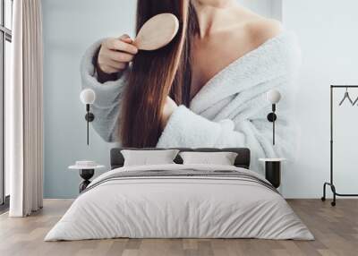 Cute, young woman in a soft, terry dressing gown, combing her hair after Spa Services and Spa Treatments Wall mural