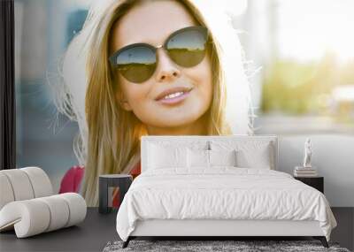 Outdoor fashion portrait of young pretty   blond woman in sunny day on street. Girl in sunglasses outdoor. Wall mural