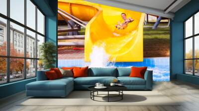 Funny excited man enjoying summer vacation in water park riding yellow float laughing. Wall mural