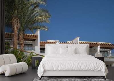 Palm trees against white home by the beach with blue sky and sand The top of the house or apartment with nice window Wall mural