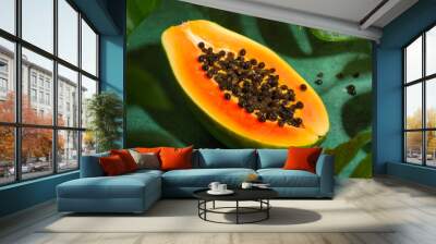 Fresh half of papaya with seeds on tropical leaves background. Tropical exotic fruit. Wall mural