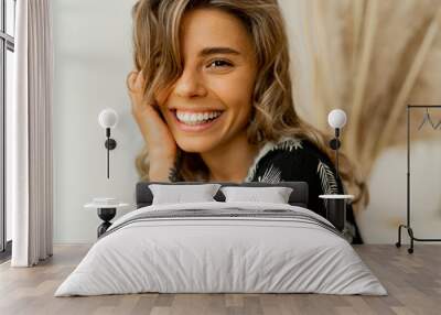 Close up portrait of  blond woman with perfect smile in stylish boho autfit. Posing in inerior studio over white background. Wall mural