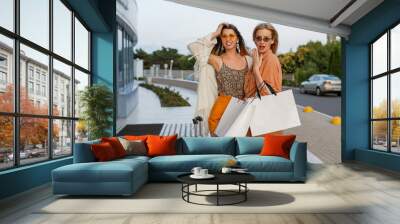 Elegant women after exiting trip and shopping posing outdoor near airport. Trendy linen clothes and boho dress. Wall mural