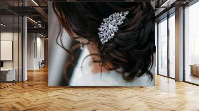 woman's crystal hairpin on the bride's wedding hairstyle with dark hair. hairstyle like a loose bun. soft curls are gathered in a bun Wall mural