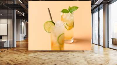 Refreshing orange two lemonade sodas with lime slice on color background. Summer fresh drink. Wall mural