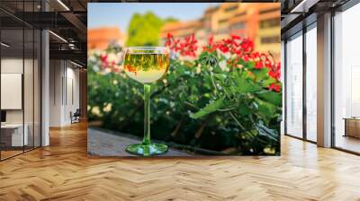 A glass of Gewurztraminer wine at an outdoor restaurant, blurred half timbered houses and flowers in the Petite France district of Strasbourg, France Wall mural