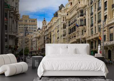 Beautiful buildings on the famous Gran Via shopping street and people walking in the center of the city in Madrid, Spain Wall mural