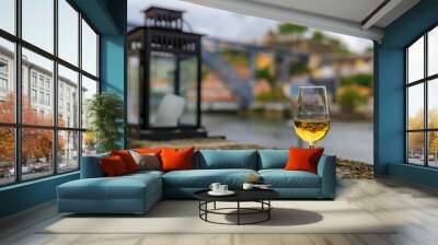 Glass of port wine with the blurred cityscape of Porto Portugal and a lantern in the background Wall mural