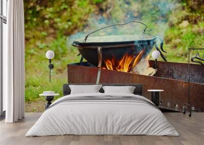 outdoor cooking area. The cauldron boils, the food is cooked on fire and firewood Wall mural