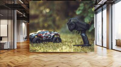 Professional remote control of a radio-controlled car. A children's toy with a remote control for racing. A small SUV on the green grass. The monster truck machine is on the control panel. Wall mural