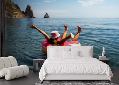 Summer vacation woman in hat floats on an inflatable donut mattress. Happy woman relaxing and enjoying family summer travel holidays travel on the sea. Wall mural