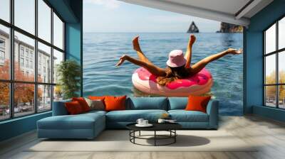 Summer vacation woman in hat floats on an inflatable donut mattress. Happy woman relaxing and enjoying family summer travel holidays travel on the sea. Wall mural