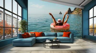 Summer vacation woman in hat floats on an inflatable donut mattress. Happy woman relaxing and enjoying family summer travel holidays travel on the sea. Wall mural