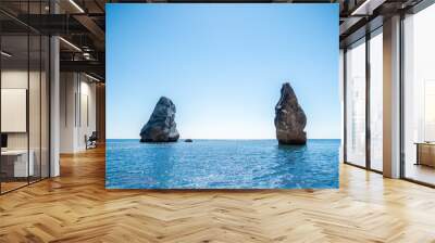 Two rocks stick out of the water in the middle of the turquoise sea. Scenic ocean views. High quality photo. Like in Iceland Wall mural